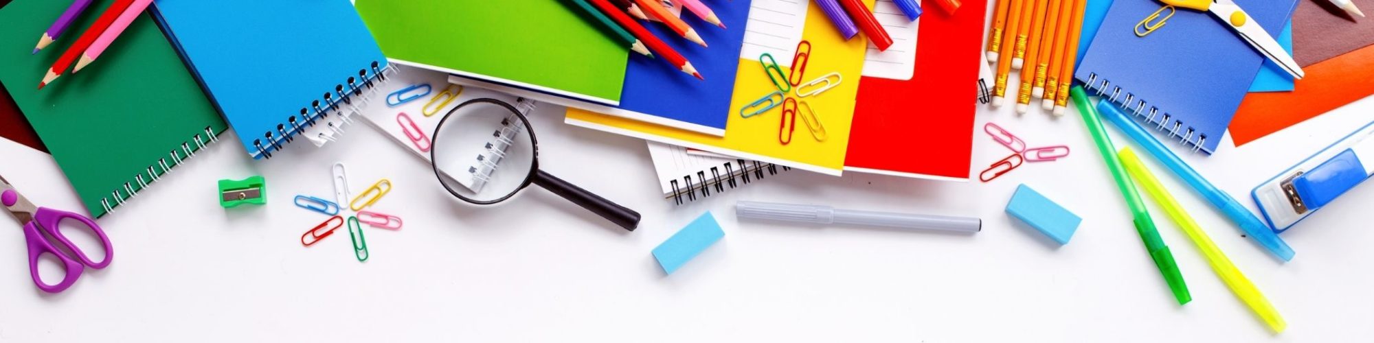 School Supplies scattered on a white desk background