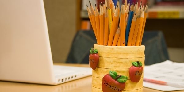 Pencils in a cup on a teacher's desk
